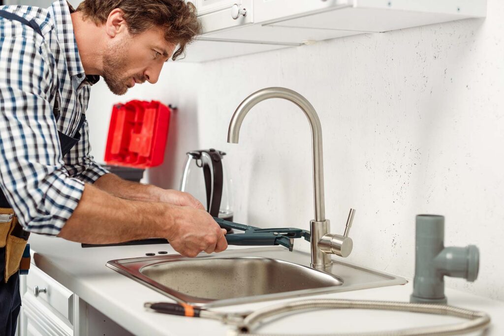 Plumber fixing kitchen sink