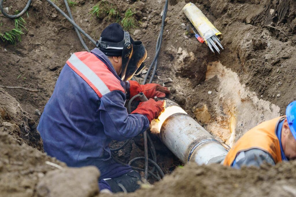 Plumber fixing broken water main sewerage
