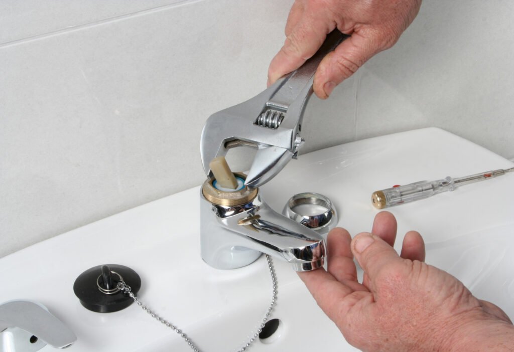 Plumber repairing the faucet of a sink.